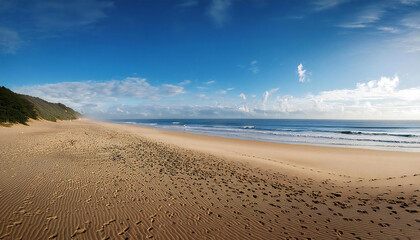 広い砂浜が広がる海岸。青空の広がる砂浜。A coast with a wide sandy beach. A sandy beach with a blue sky.