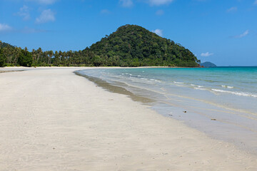 Empty Koh Chang beach with white sand and tropical forest.