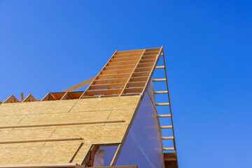 Installing wooden roofing trusses under construction roof on house