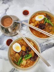 Popular street food. Malaysian Curry Noodle Soup aka Laksa Malaysia. It is a common stable hawker...