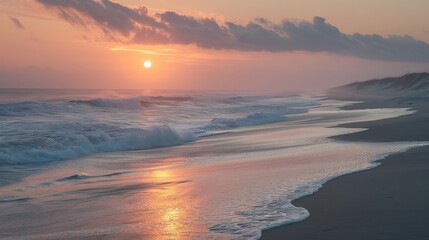 Sunset over a calm ocean with breaking waves on a sandy shore