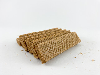 crispy wafer sticks arranged in a staggered pattern on a white background. The wafer sticks have a light brown color and a delicate texture. Wafers with chocolate flavored cream on a white background