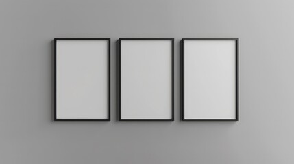 Three black framed pictures, vertically aligned, on a light grey wall.