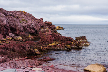 Bizarre colorful rock formations at the Tickle Cove Sea Arch, located on the Discovery Trail of the Bonavista Peninsula in Eastern Newfoundland
