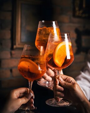 Friends toasting with Aperol Spritz cocktails.