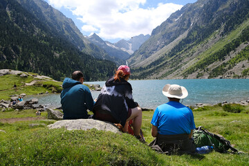 Group of tourists are sitting over lake Lac de Gaube. Beautiful scenery of Pyrennes National Park....