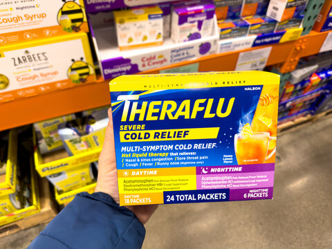 Large pack of Theraflu cold relief medicine. Packets of medicated hot beverage ingredients.