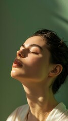 Fototapeta premium Person in full-length, feeling serene and peaceful, their eyes closed and a slight smile on their lips, set against a soft green background that evokes a sense of calm and tranquility.