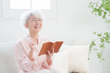 手帳にメモするシニア女性