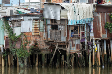 Shanty house along Kenh Te canal in Ho Chi Minh City, Vietnam. House is built from iron sheets and supported by wooden piles into the water.