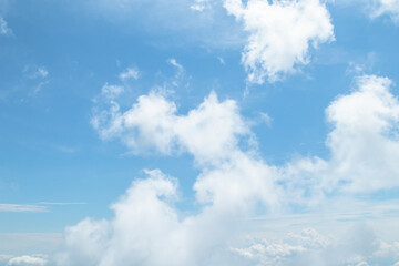 Morning view over white puffy clouds with blue sky on horizon.