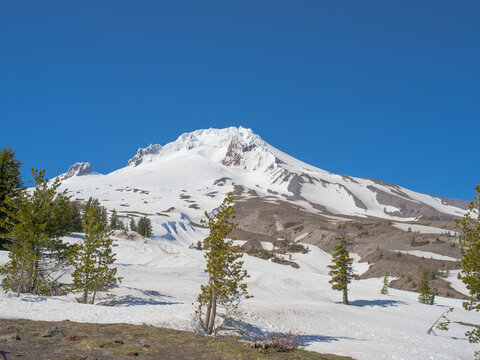 A mountain covered in snow with a blue sky in the background