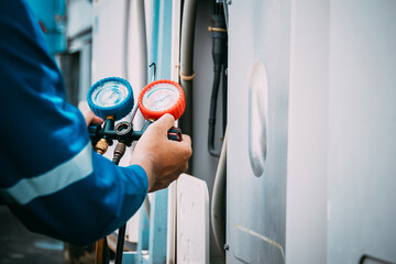 Technician is checking air conditioner refrigerant leak.