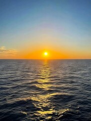 Obraz premium A sunset over the ocean with the sun setting in the distance