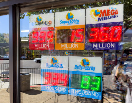 Closeup of LED Lottery jackpot in millions display behind a glass of a convenience store.