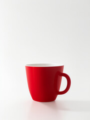 Obraz premium A solitary, vibrant red cup sits centered on a crisp, white background, its bright, fire-engine hue radiating warmth and coziness