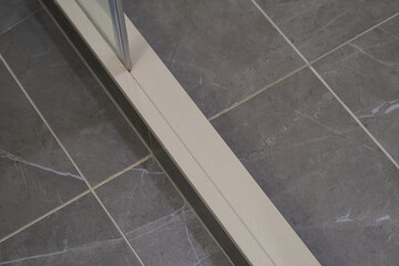 Modern design bathroom with detail close up of glass shower with stone tiles in cabin or stateroom...