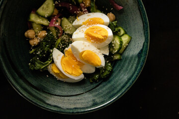 Bowl with salad and hardboiled egg topped with sesame seeds