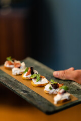 platter of prosciutto and ricotta crostini being served at event