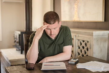 Man putting his hand to his head looking at a bill