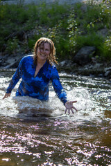 Woman joyfully playing in a creek and enjoying nature