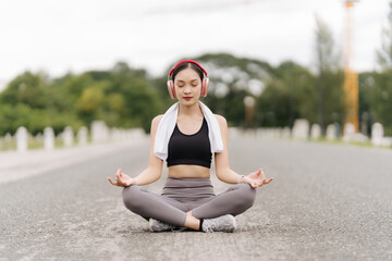 Fototapeta premium Asia woman practices yoga and meditates at park. Healthy lifestyle and Yoga concept.