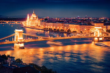 Obraz premium Illuminated summer cityscape of Hungarian parliament building with famous Chain Bridge on the Danube river. Spectacular evening cityscape of Budapest, Hungary, Europe.