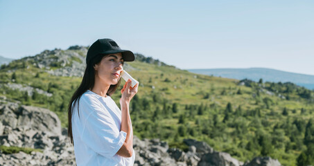 Woman applying sun cream in the summer mountain .Spf stick 