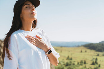 Relaxed woman breathing fresh air in a green summer mountain