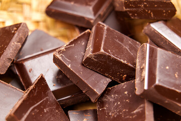 Dark cracked broken bitter chocolate pieces. Macro