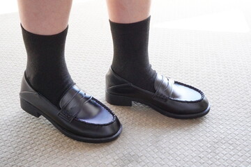 黒いローファーを履いている小学5年生の女の子の足元