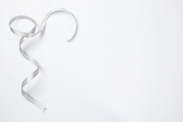 One beautiful grey ribbon on white background, top view. Space for text