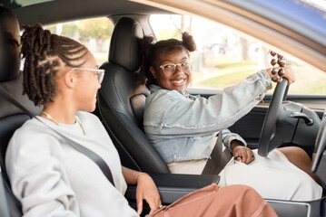 African American friends laughing together while driving