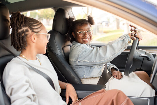 African American friends laughing together while driving - Powered by Adobe