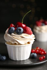 Tasty cupcake with different berries on grey table, closeup