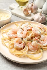 Delicious pasta with shrimps served on grey table, closeup
