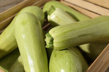 Fresh ripe zucchinis in wooden crate, closeup