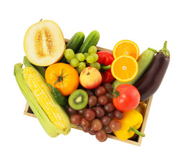 Different fresh fruits and vegetables in crate isolated on white, top view
