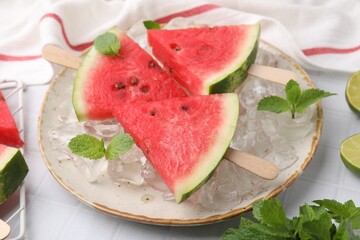 Pieces of tasty watermelon, ice cubes and mint on table, closeup
