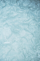 Turbulent water surface with visible foam and ripples.