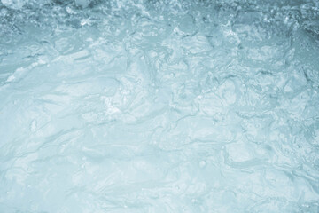 Turbulent water surface with visible foam and ripples.