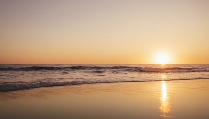 serene sunset casts warm glow on the tranquil ocean, with the sun's reflection visible on the wet sand.