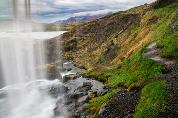 Behind a Waterfall in Island - Waterfall with Mountains, Sky and Clouds