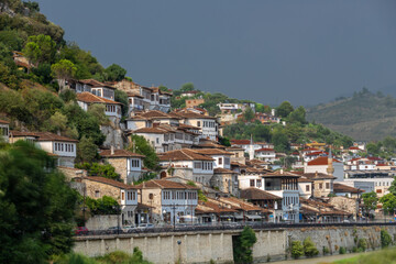 Naklejka premium Sunset over the UNESCO town of Berat on the Osum River in Albania and known for its white Ottoman houses also called the city of One Over One Windows and built against the hill side below the citadel