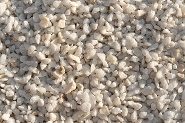 A close-up image of white gravel stones, ideal for backgrounds, textures, and construction-related themes.