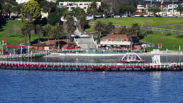 This video features a sunny coastal scene with water, a pier, and pool