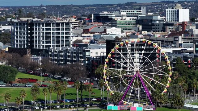 Aerial view of a city skyline featuring a ferris wheel, showcasing urban life
