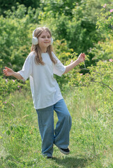 Obraz premium A child with headphones listening to music and dancing