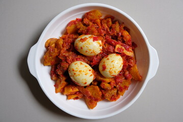 Telur balado or spicy boiled egg in a white plate. Traditional food originated from West Sumatra, Indonesia.