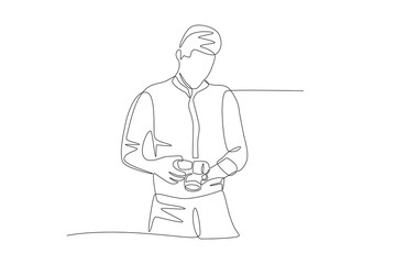 Male photographer looks at the photos he has taken. World photography day concept one-line drawing